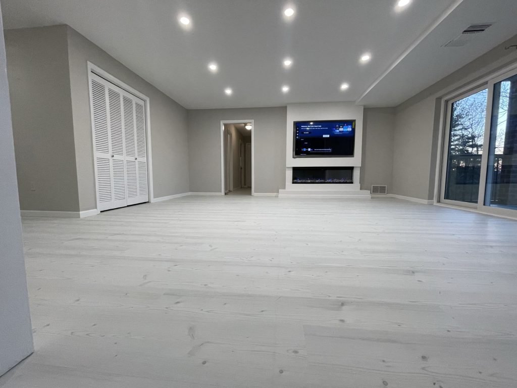 Open living area with new flooring and recessed lighting