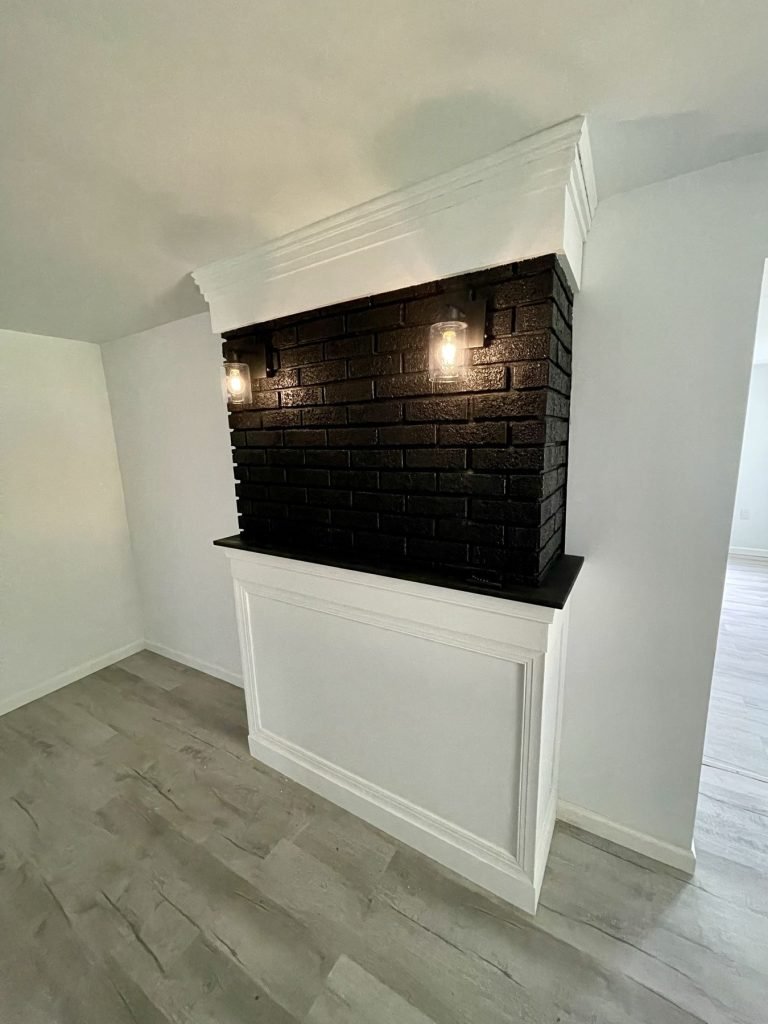 Painted black brick chimney with white panelled surround