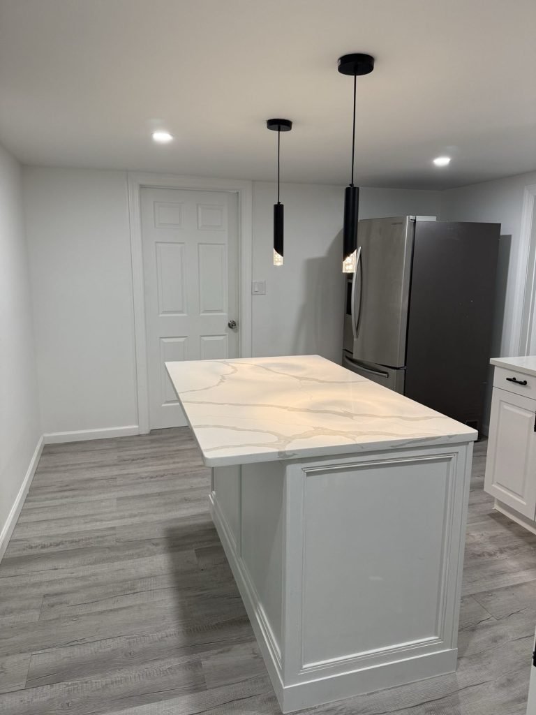 Kitchen island with pendant lighting and gray plank floor