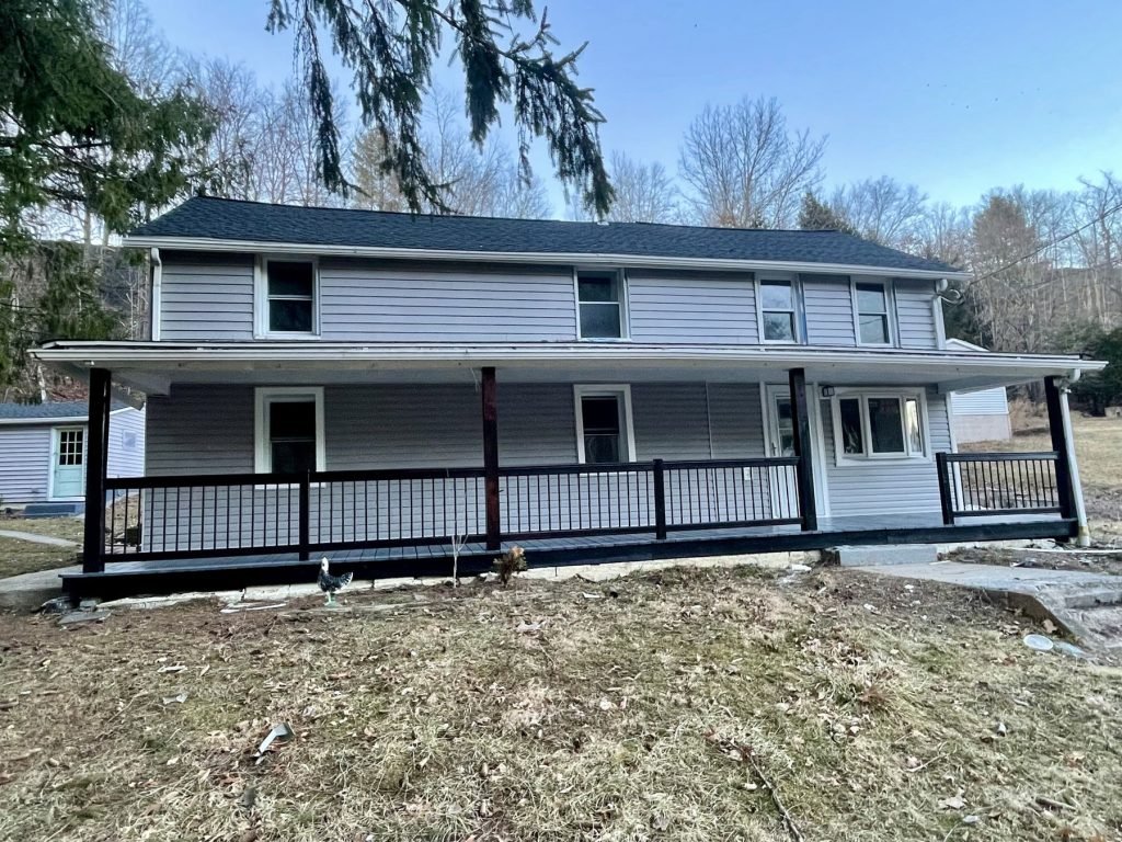 Rebuilt farmhouse porch with new siding and railing