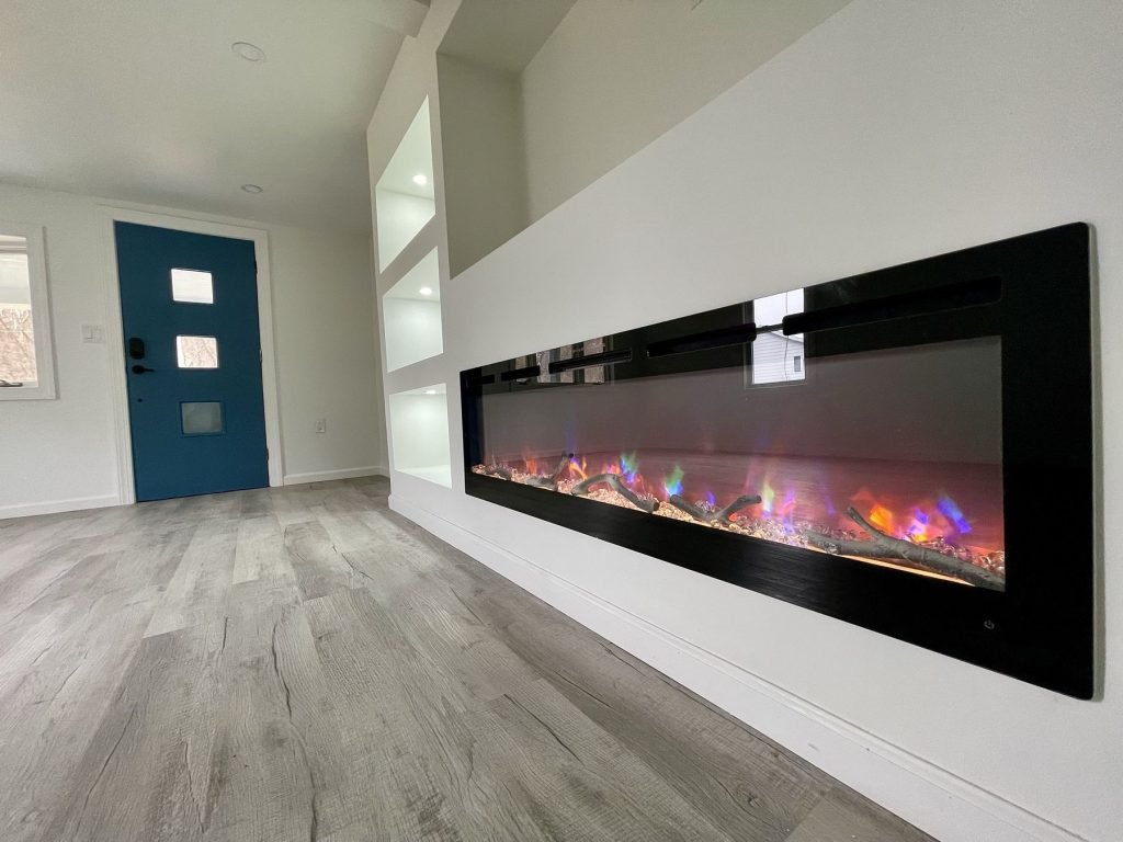 Linear fireplace built-in beside a teal front door