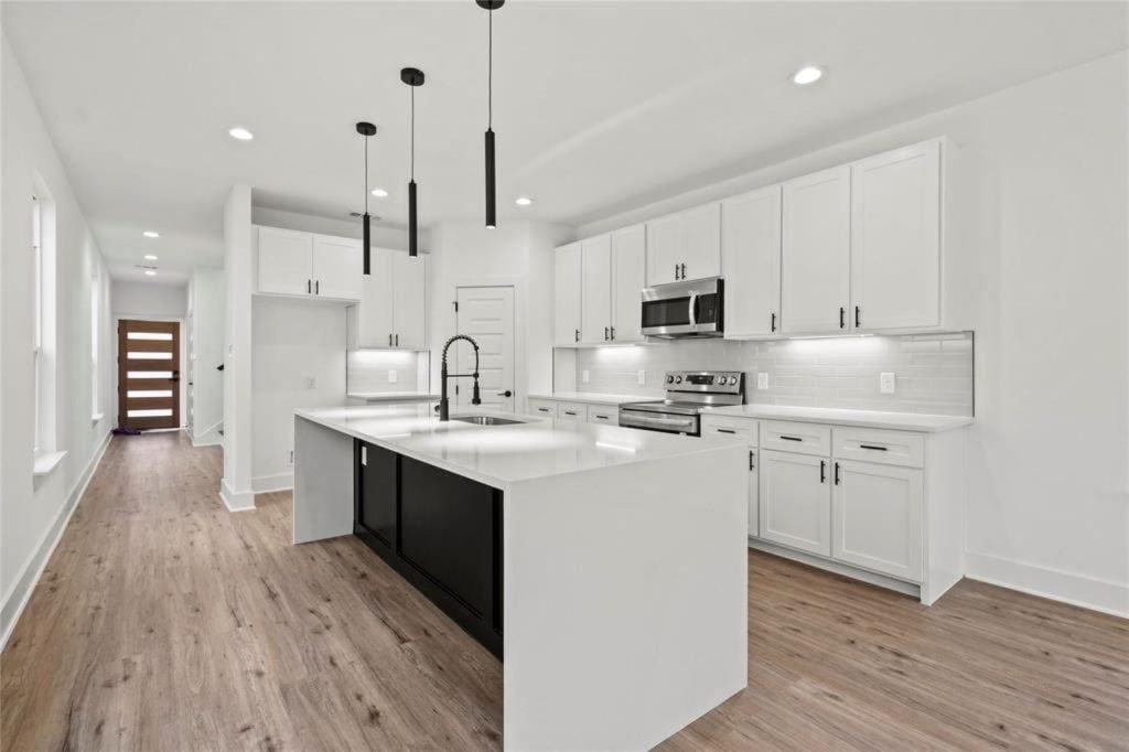 Open-plan kitchen remodel with waterfall quartz island and black pendant lights in Reading, PA