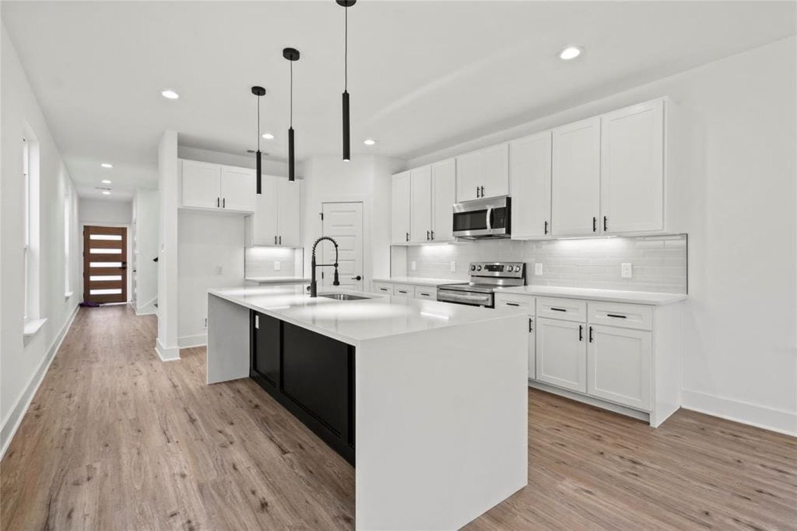 Open-plan kitchen remodel with waterfall quartz island and black pendant lights in Reading, PA