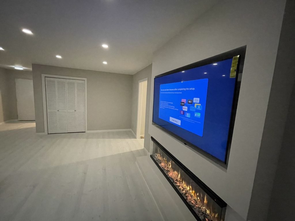 Finished basement with recessed TV and fireplace wall