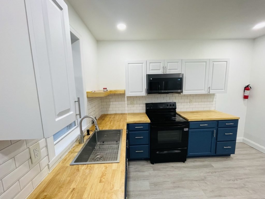 Two-tone kitchen with white uppers, navy lowers and butcher block