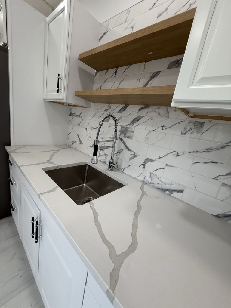 Undermount sink in quartz countertop with marble-look backsplash