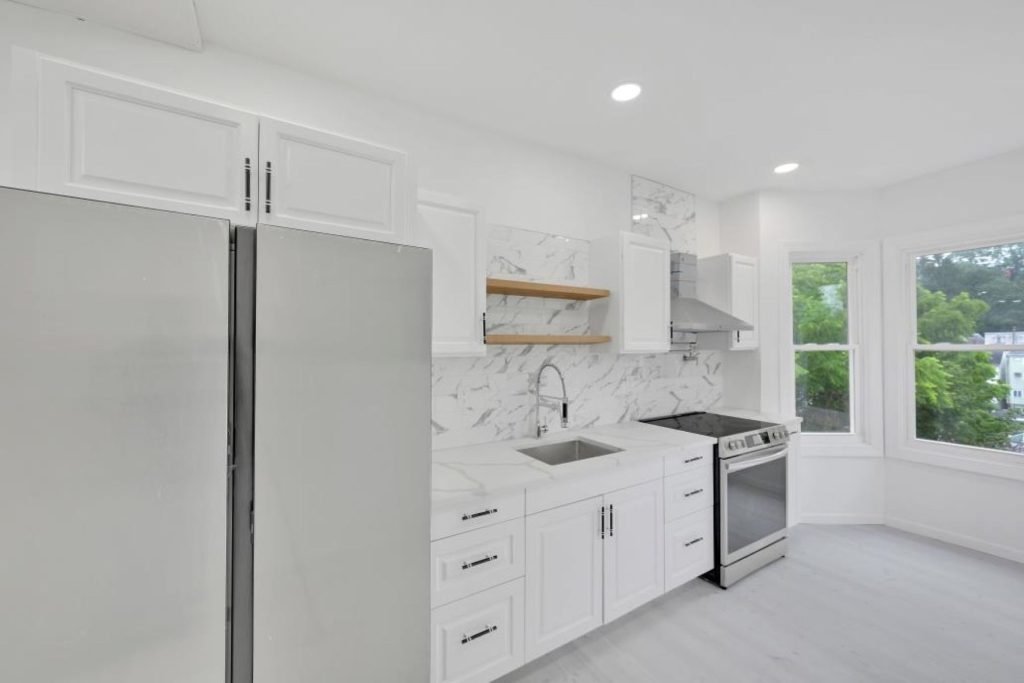 Rowhouse kitchen with stainless range and white cabinets